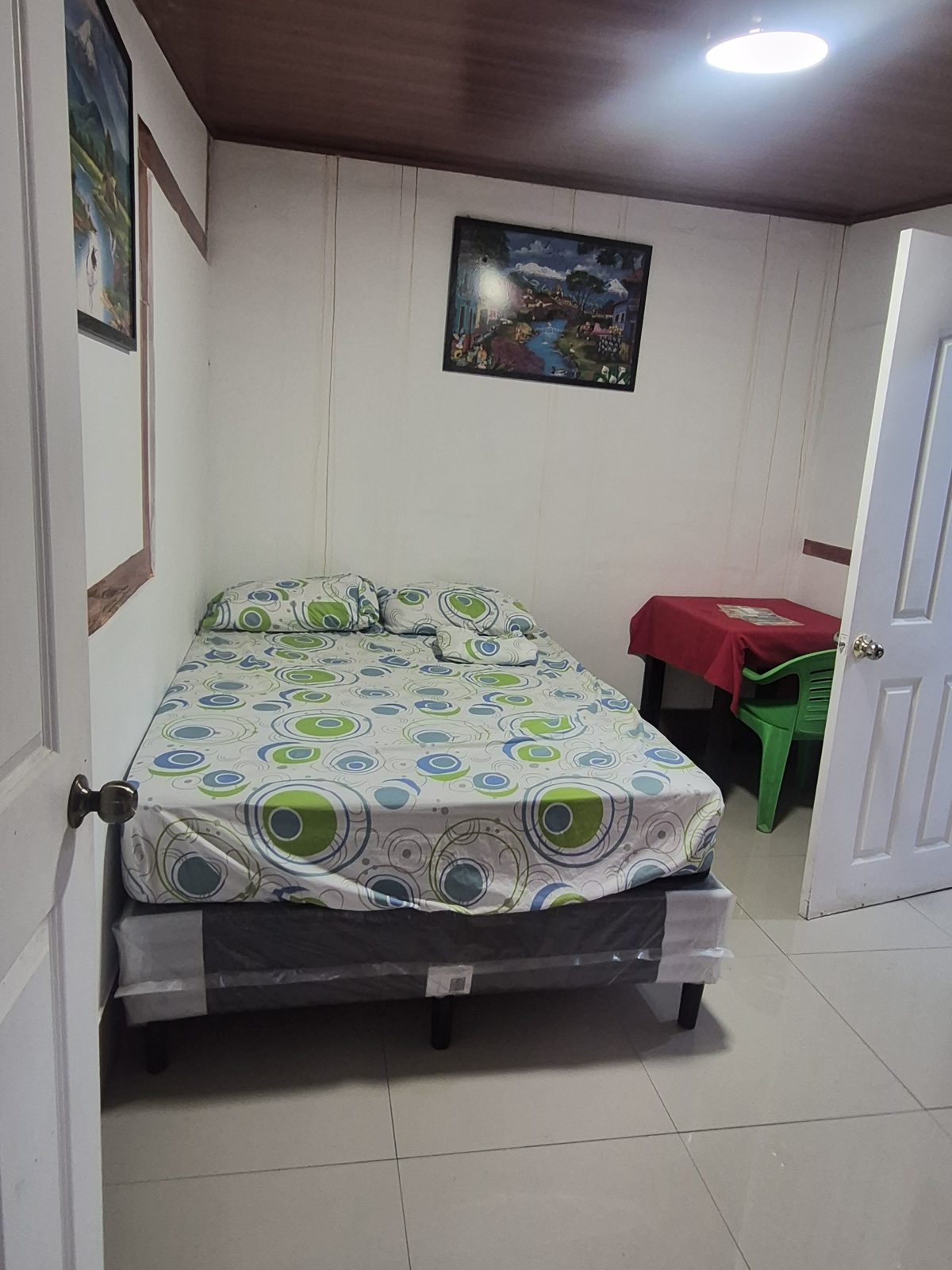 Guest room with a single bed, patterned bedspread and white walls